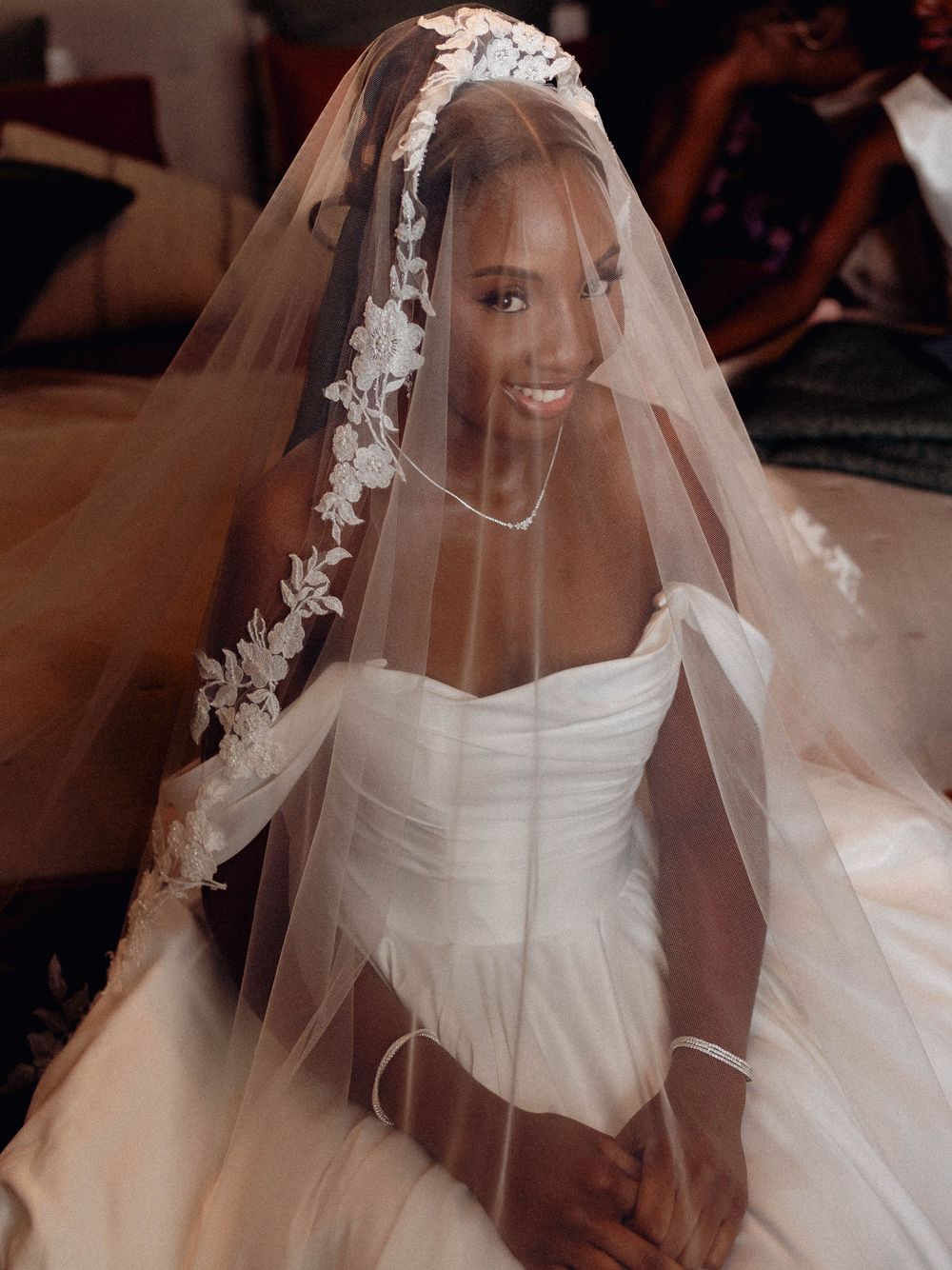 A series of close-up shots showing a bride wearing a delicate lace veil and white strapless wedding gown.