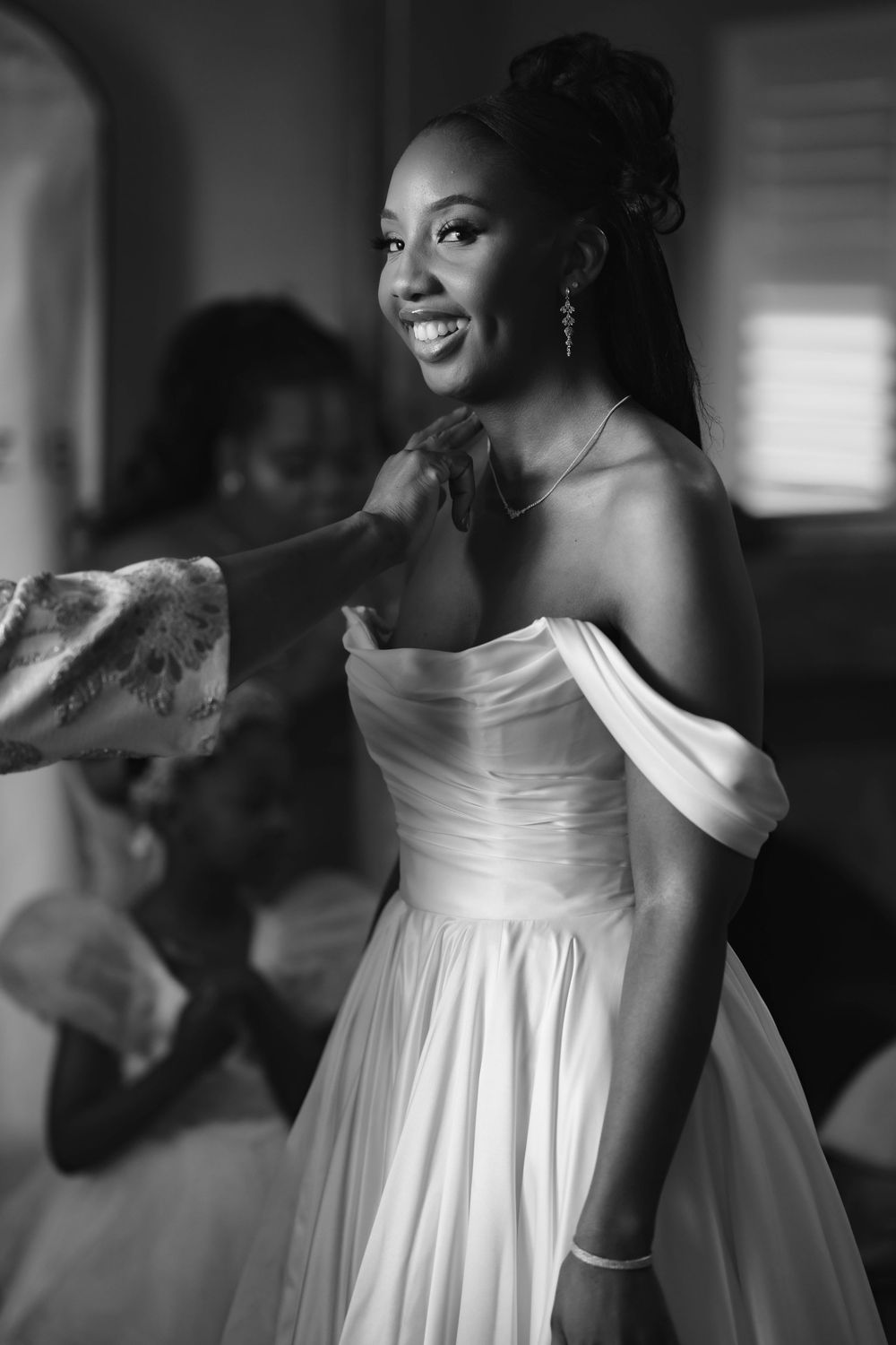 A series of black and white photos showing a joyful moment in an elegant white wedding dress.