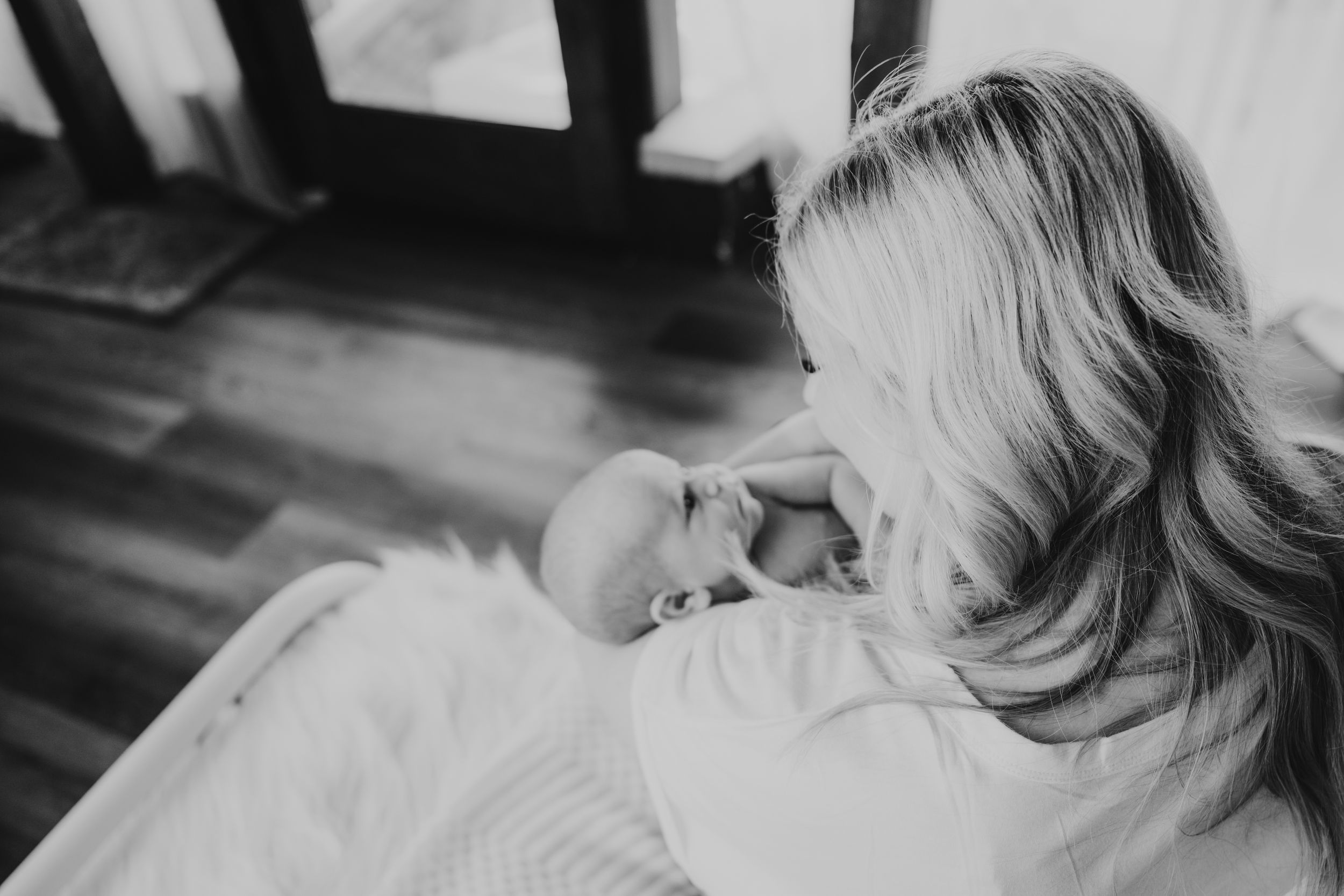 Black and white photo series showing tender moments between parent and newborn baby in hospital setting.
