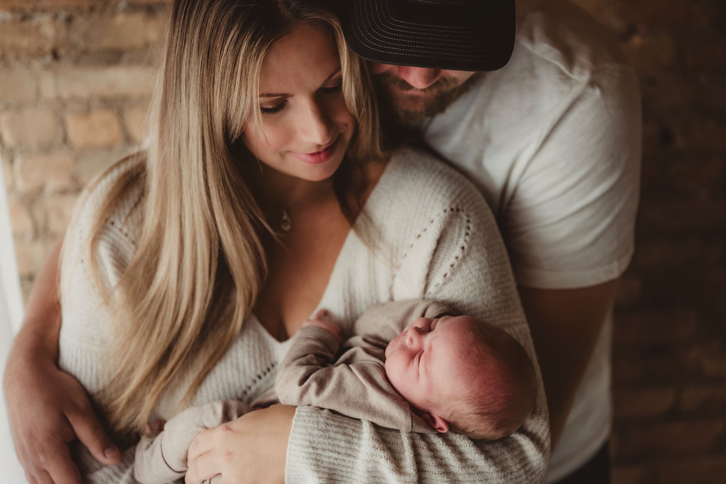 A series of intimate family photos showing tender moments between parents and their newborn baby in warm, natural lighting.
