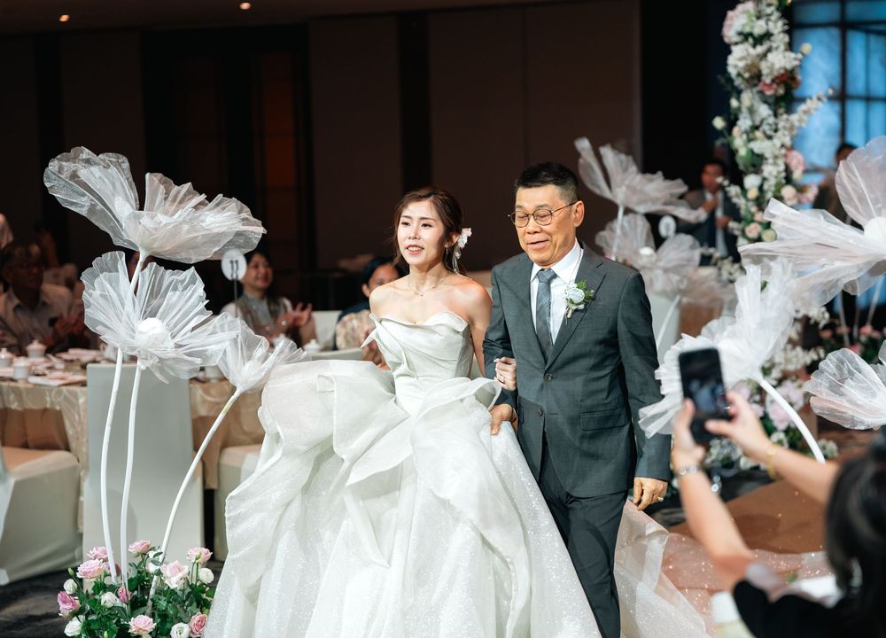 Wedding guests gather around a dance floor as a couple shares their first dance at an elegant indoor reception.
