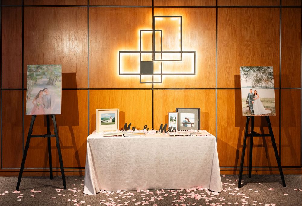 A wooden paneled wall with modern geometric artwork and scattered rose petals on the floor creates an elegant atmosphere.