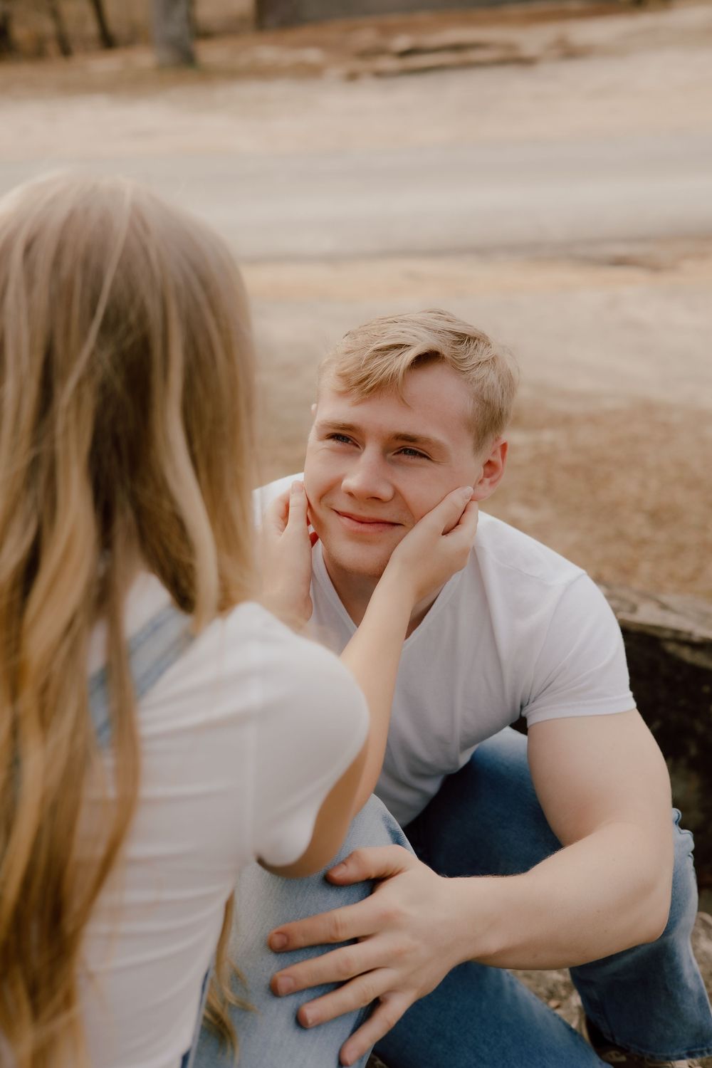 A sweet candid moment captured between two people sitting together outdoors on a sunny day.