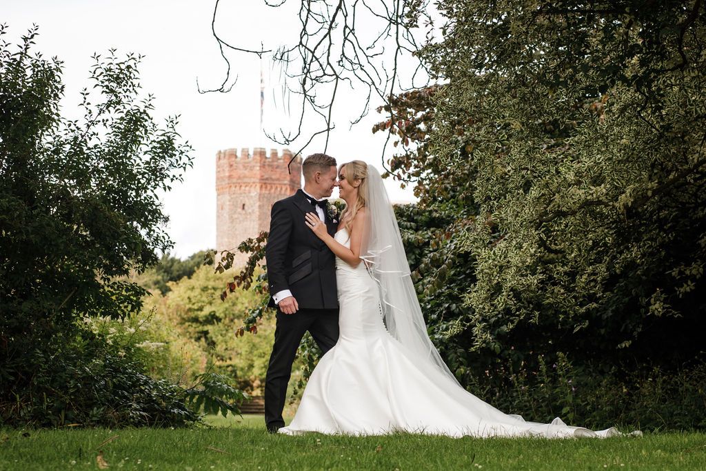 Couple sharing a relaxed laugh in the gardens of Hodsock Priory.