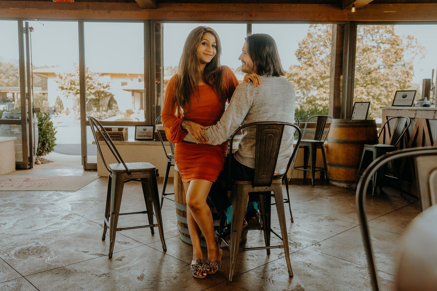 Couple sharing a romantic moment in a cozy indoor setting with wooden beams.