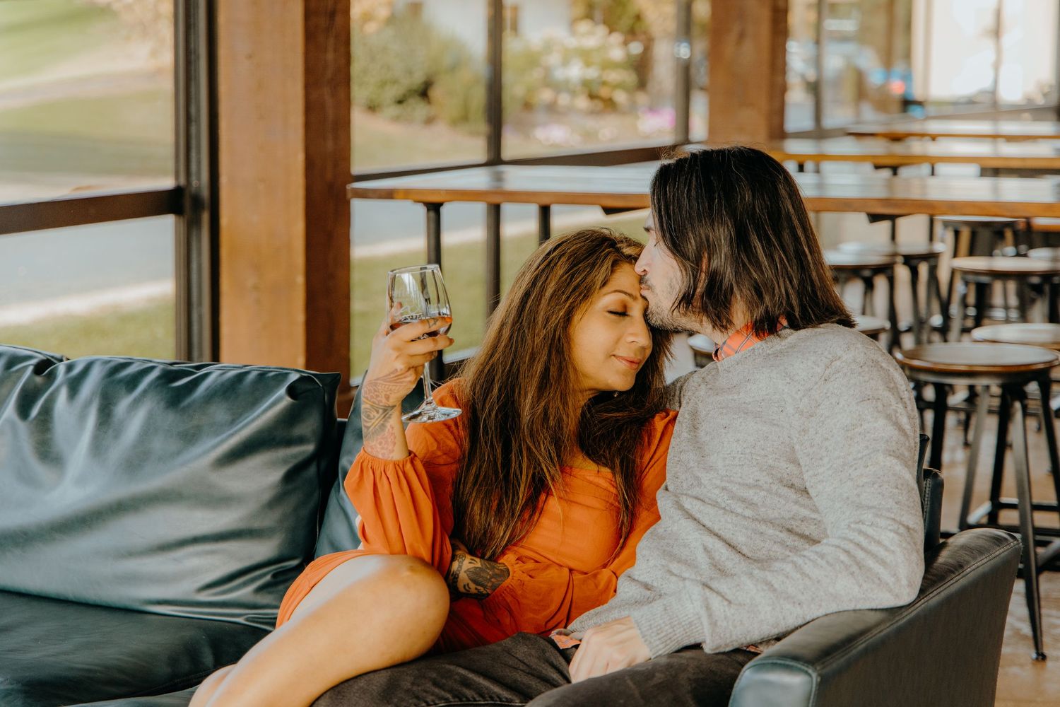 Two people relaxing on comfortable seating in a modern tasting room.
