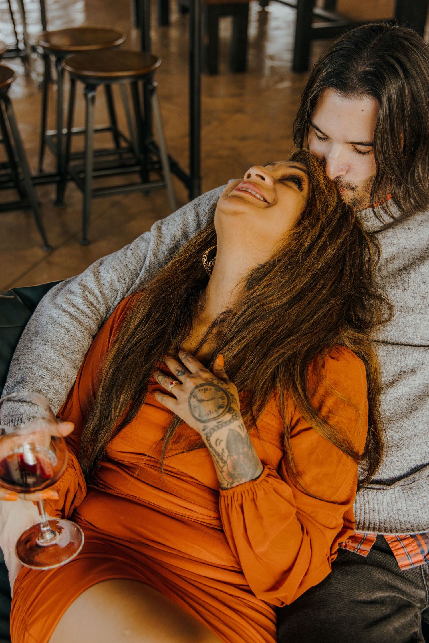 Couple enjoying wine and intimate moments in a cozy tasting room setting.
