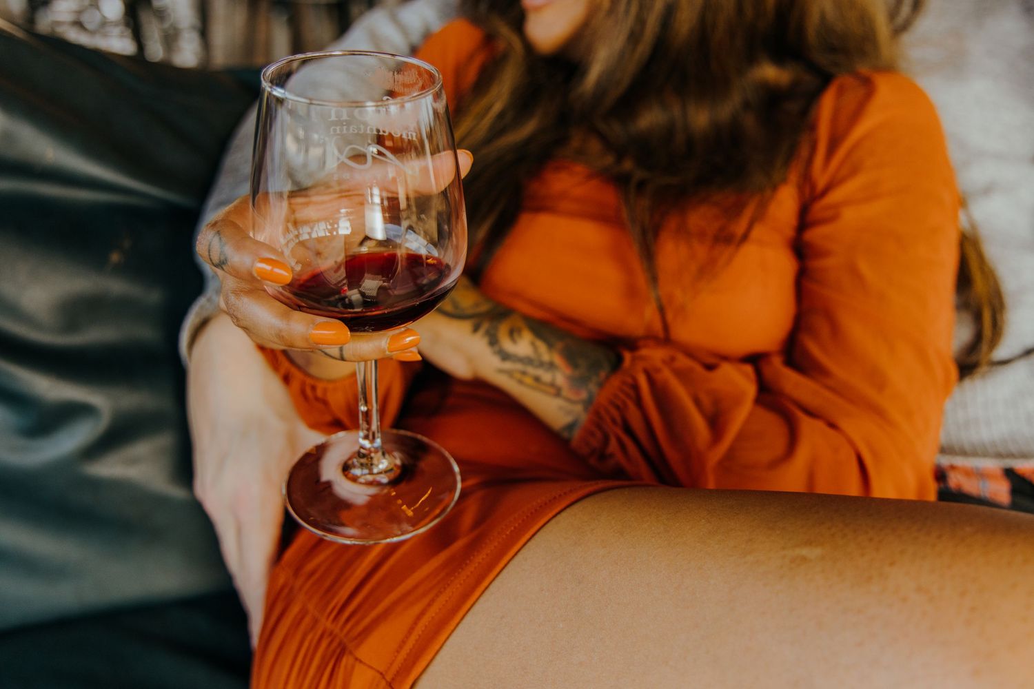 Two people sharing wine and affectionate moments in warm lighting.