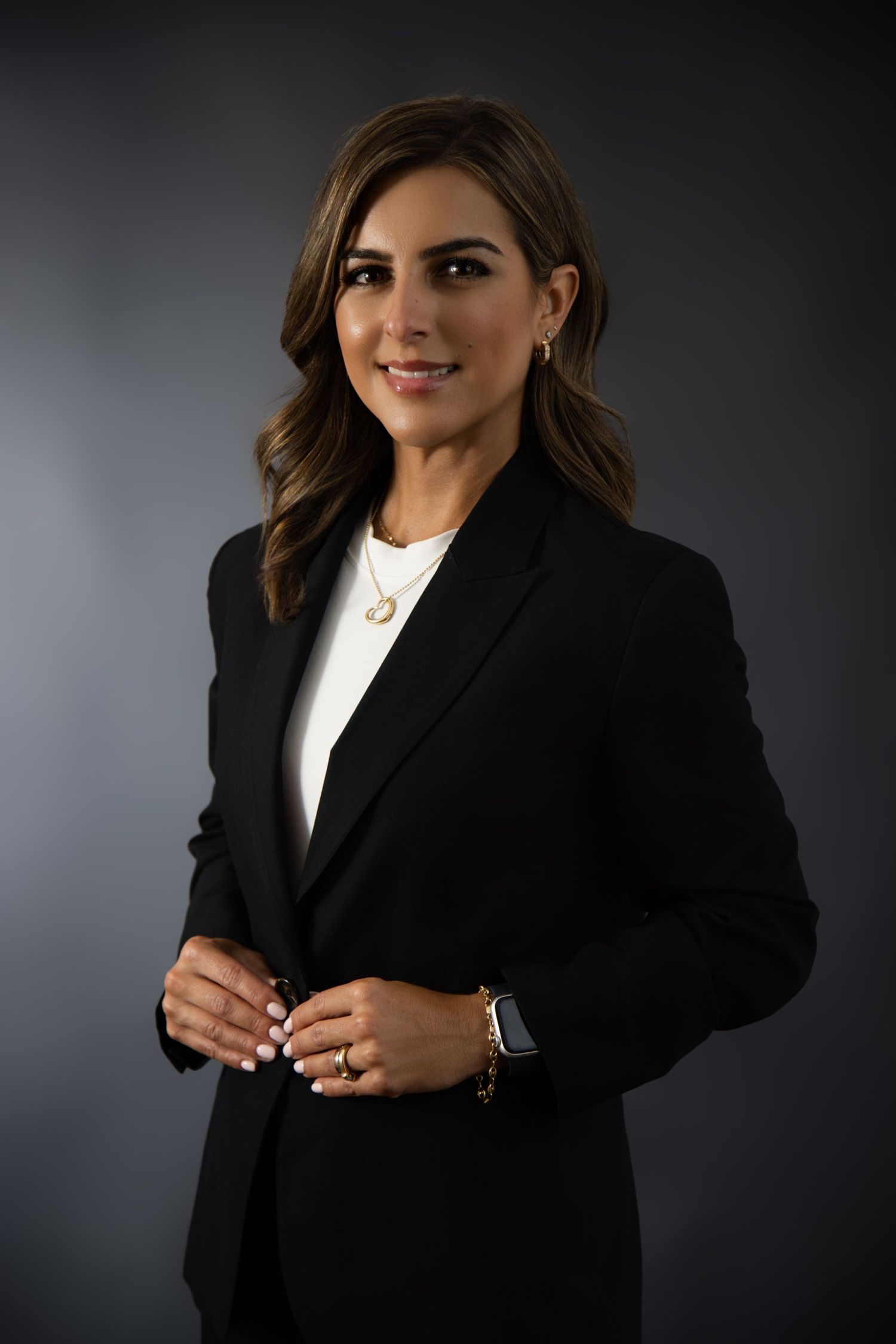Professional headshots in black blazer and white top against dark background showing various poses and expressions.