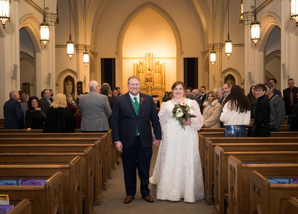 Elegant church interior with arched ceilings and pendant lighting during a wedding ceremony.