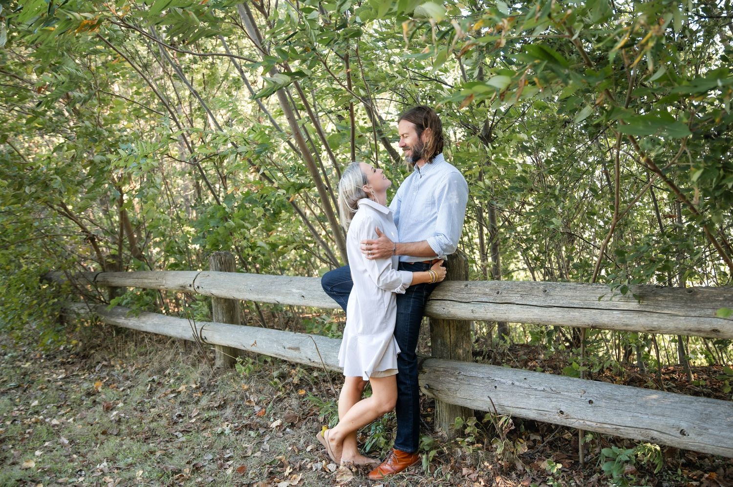 A group walks together through a natural outdoor setting during a family photography session in the woods.