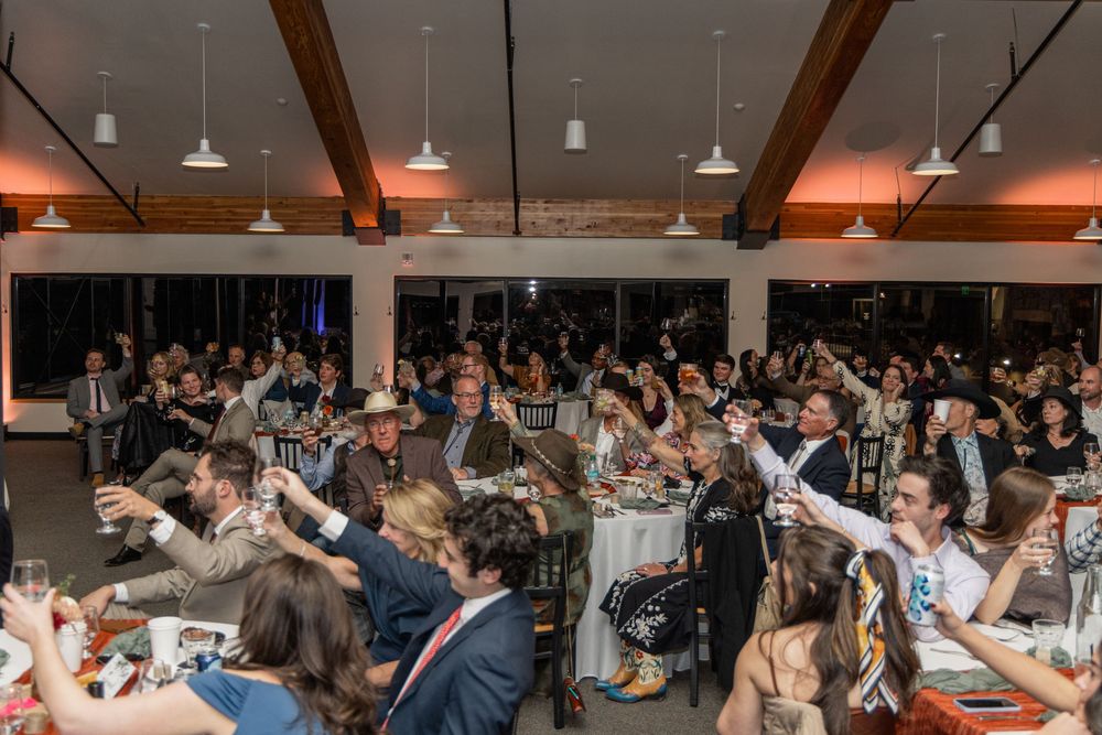 A crowded business conference room filled with attendees seated at tables during a professional event.