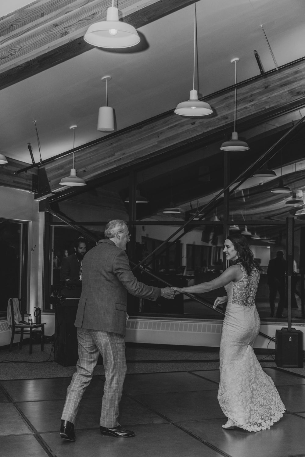 A couple dances together in a vintage black and white photograph showing graceful movement in an empty dance studio.