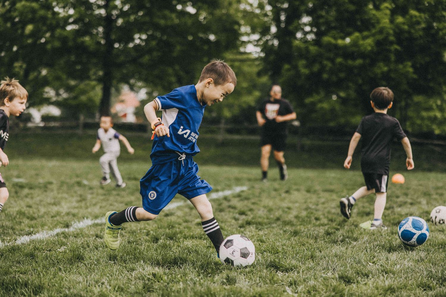 Young soccer players practice their skills on a grassy field during a training session.