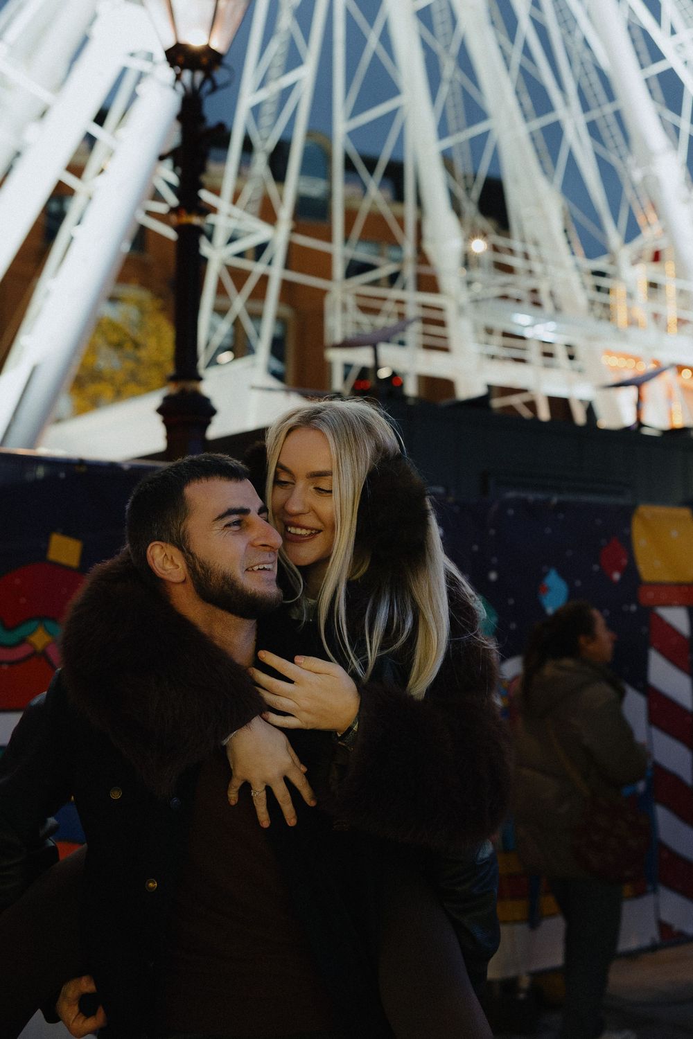 A couple sharing a romantic moment under an industrial white metal structure.