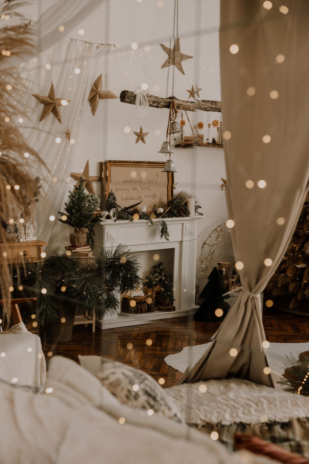Cozy Christmas decorations with gold stars and twinkling lights create a warm holiday atmosphere in a white tent setting.
