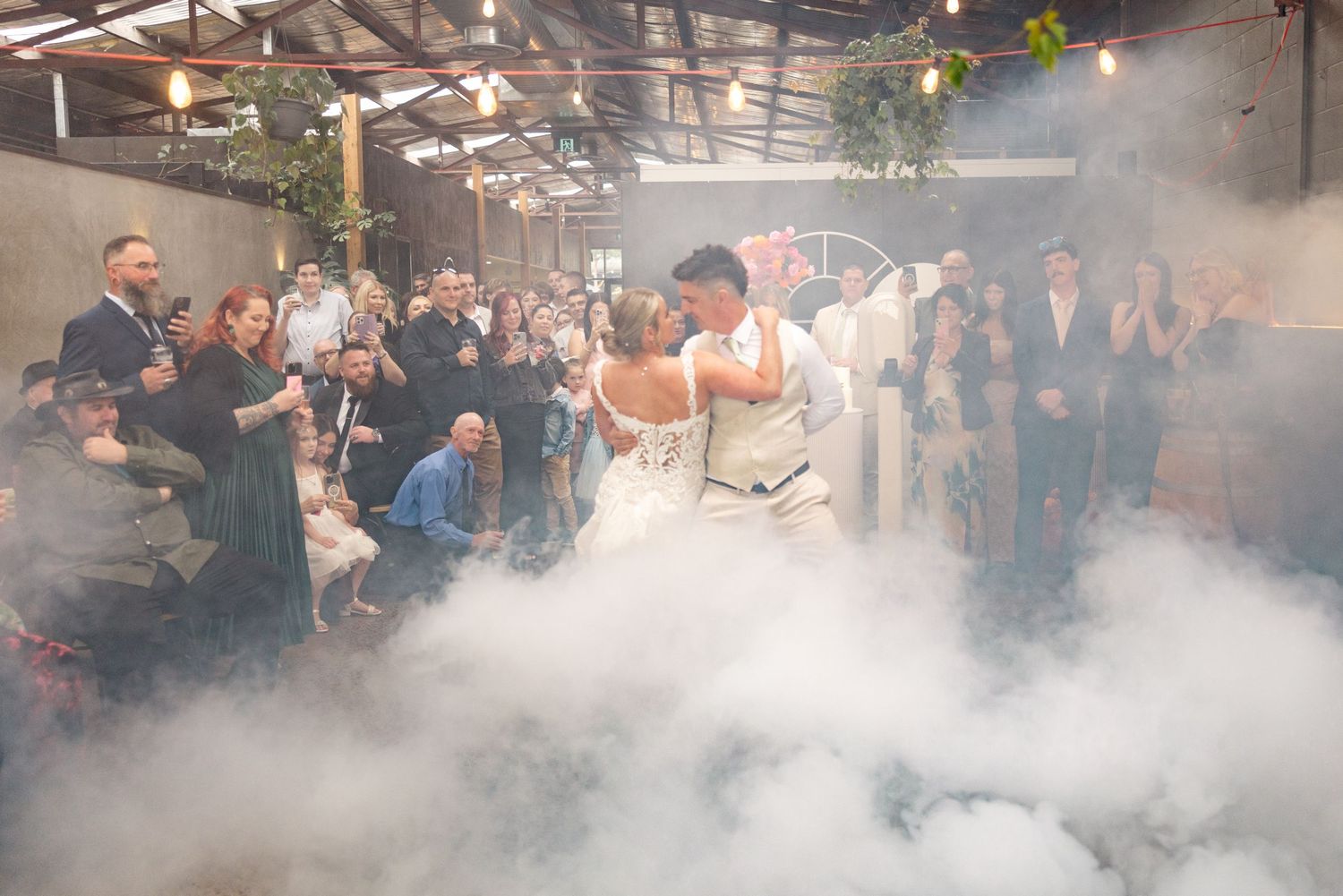 Wedding reception venue filled with smoke effects and dramatic lighting.