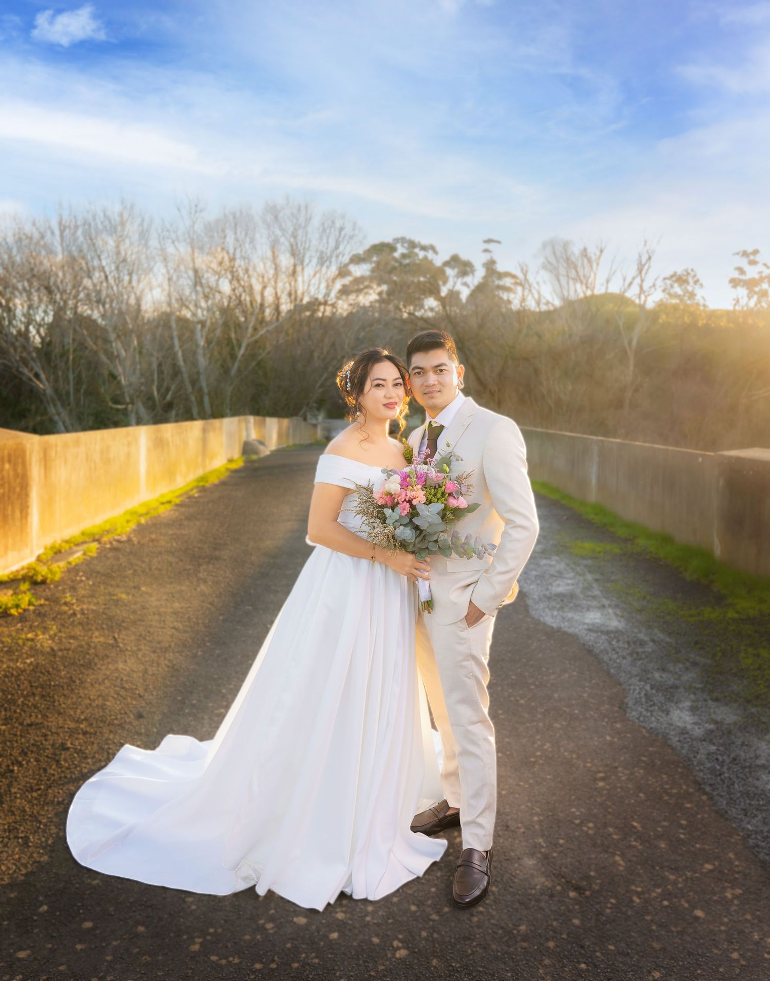 A romantic wedding photo shoot on a gravel path at golden hour.