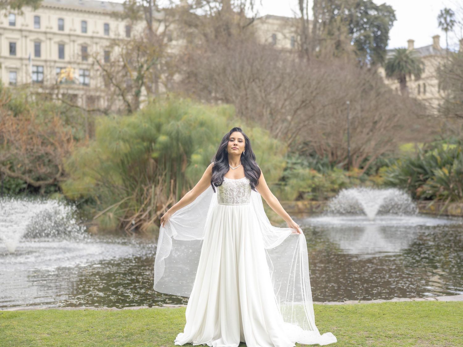A stunning bridal portrait session by a serene lake with elegant white dress details.