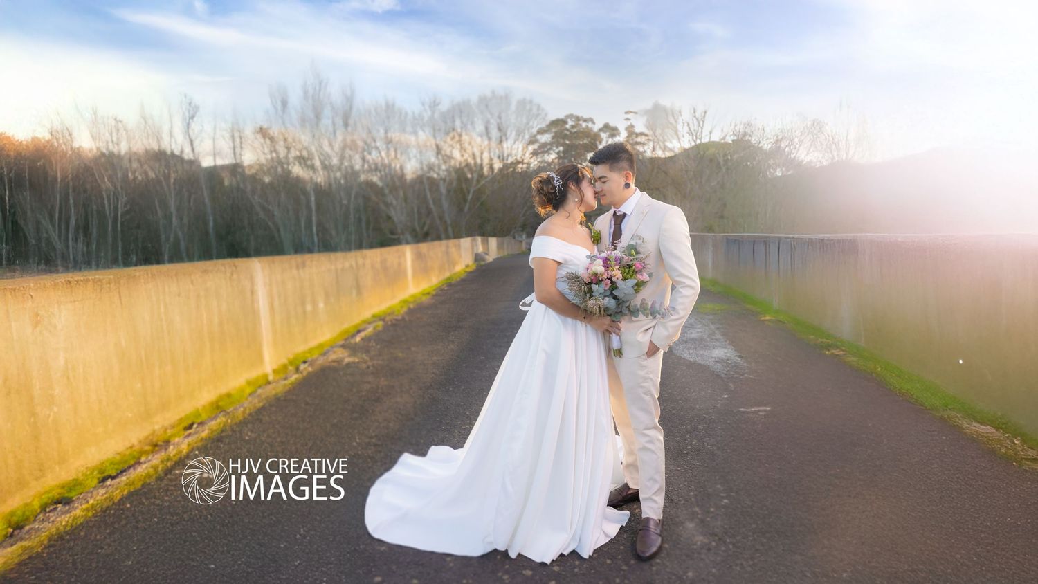 A scenic wedding photoshoot on a path with golden sunlight.