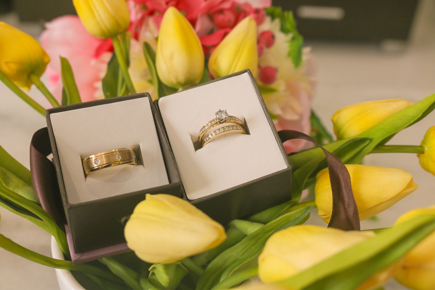 Yellow tulips and pink flowers arranged with wedding photo prints.