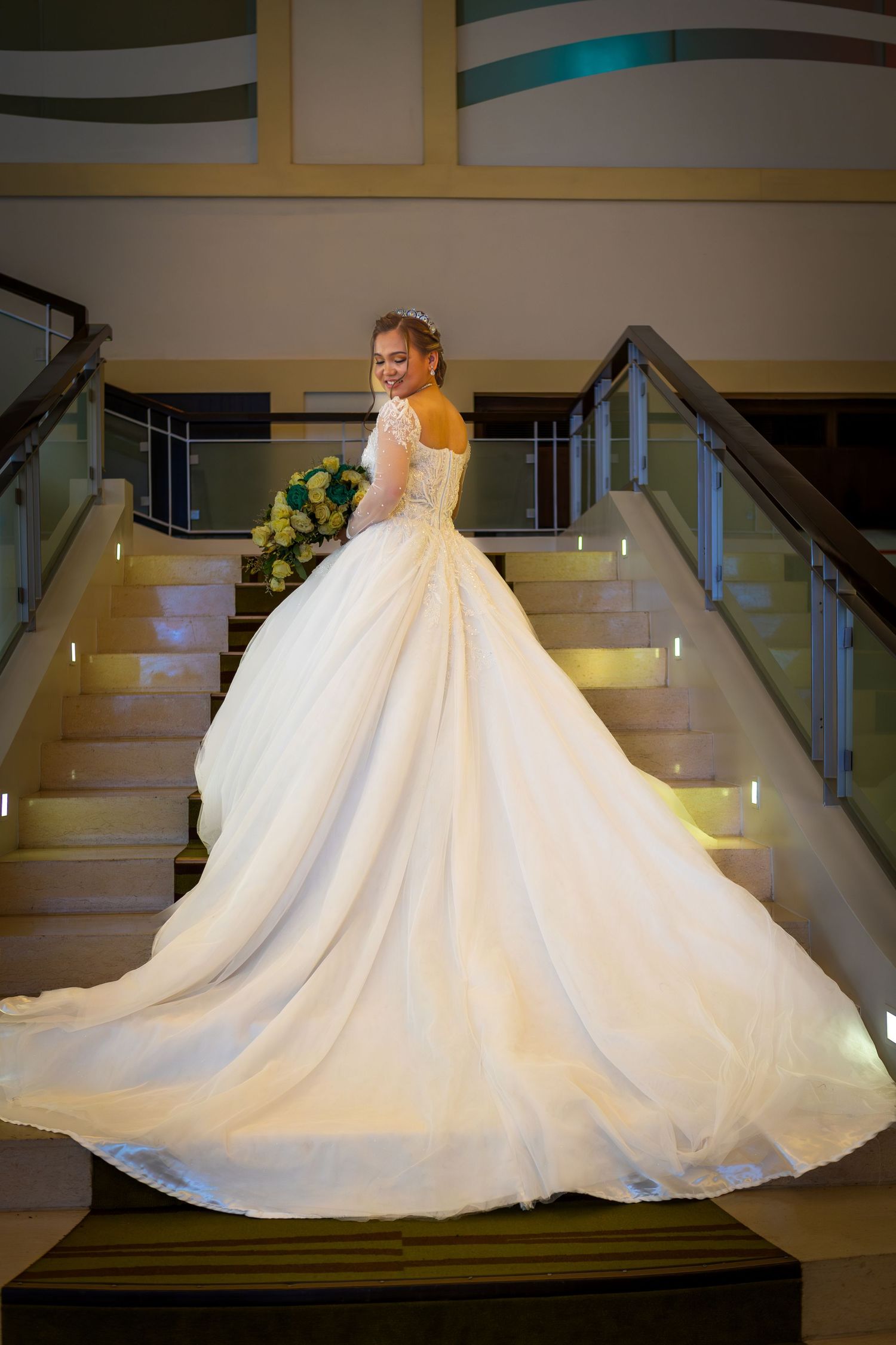 Princess ballgown wedding dress with dramatic train photographed on modern staircase.