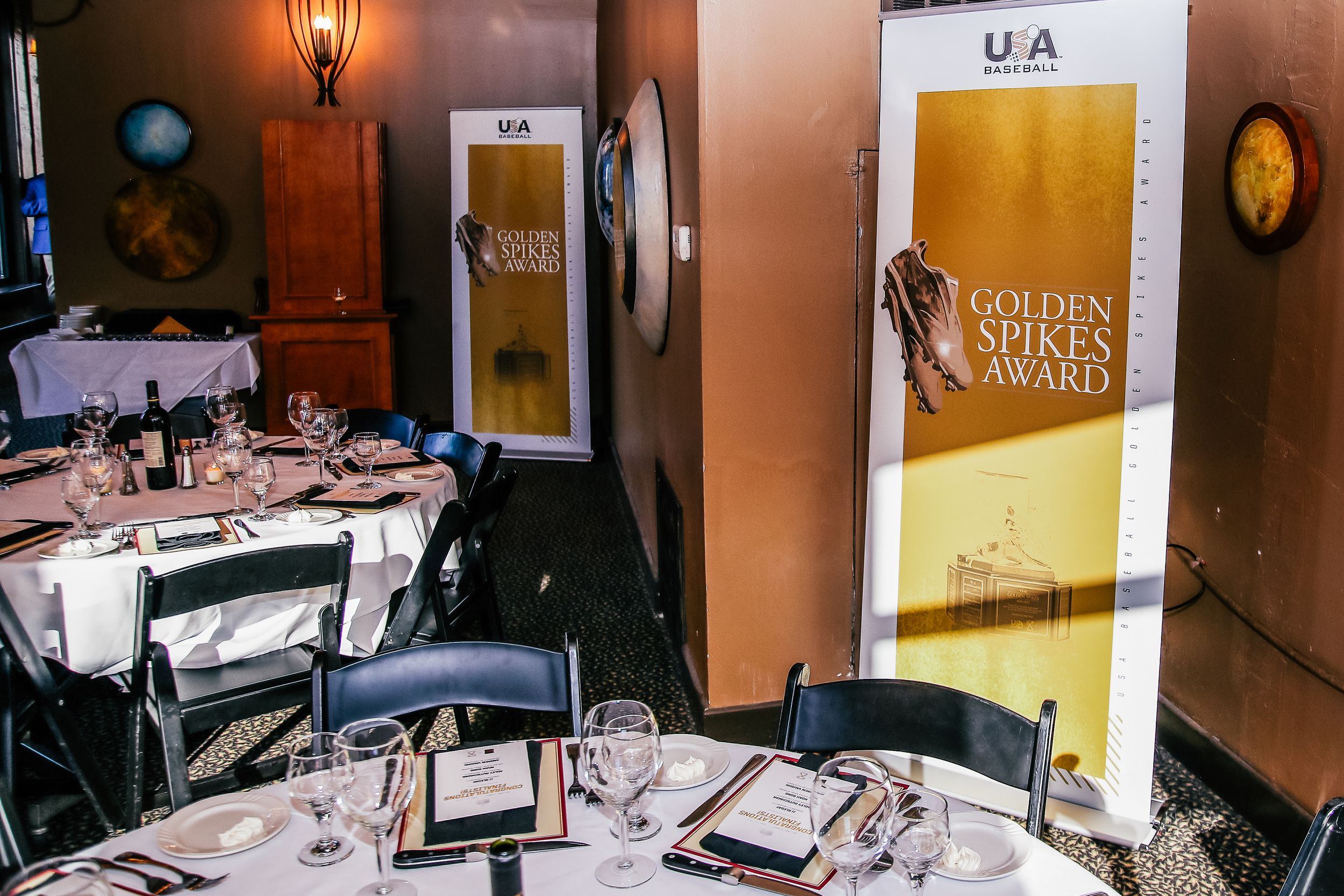 Elegant dining setup for the USA Baseball Golden Spikes Award ceremony with decorated tables and award banner.