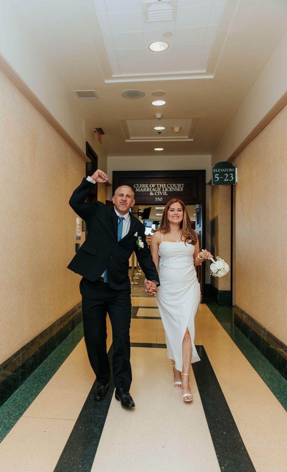 Playful sequence of a couple walking and dancing down a hallway at a wedding venue.