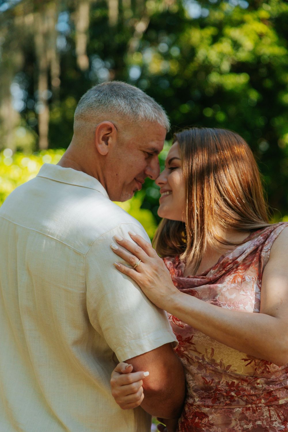 An intimate moment shared between a couple in a sunlit garden.