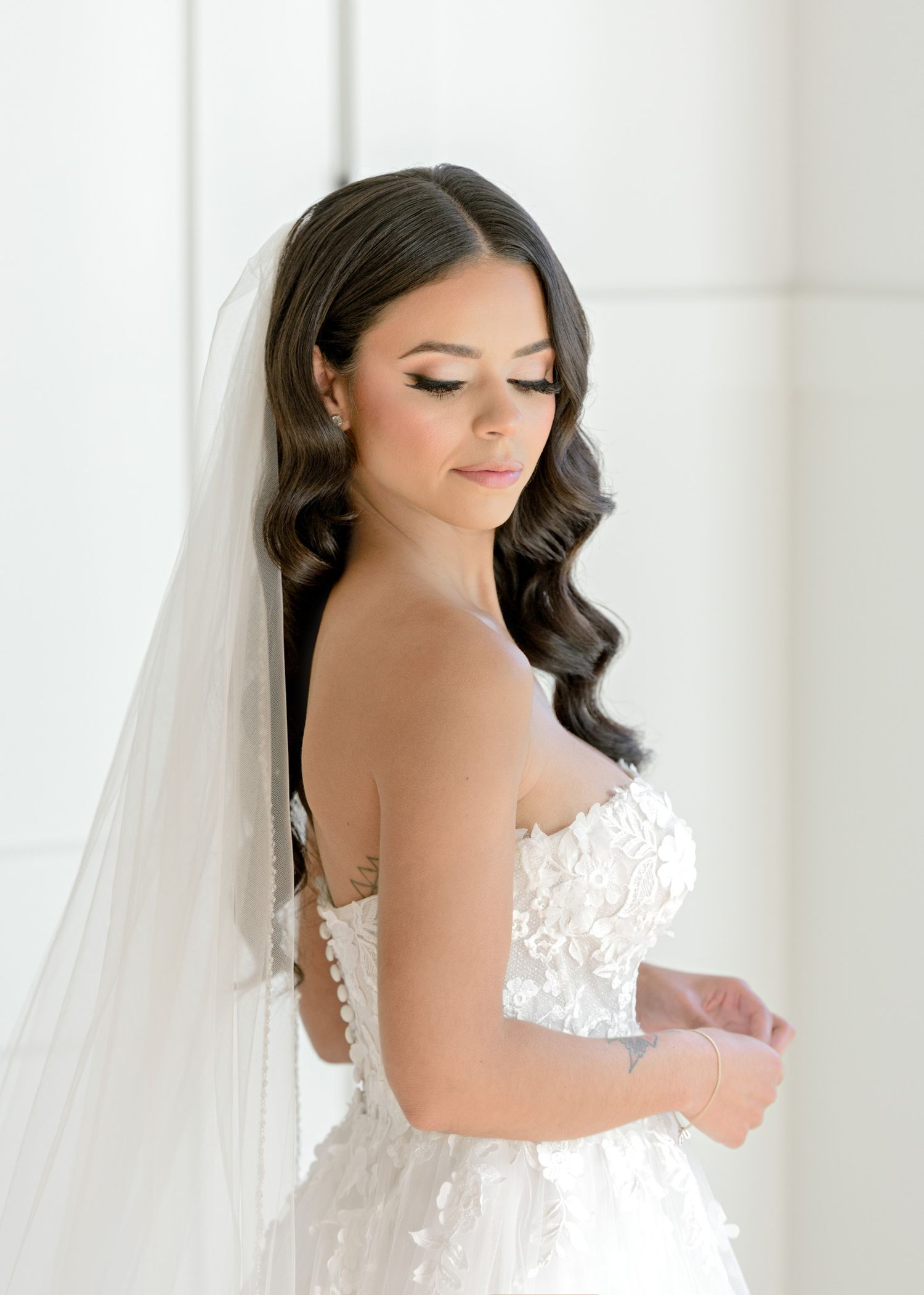 A stunning bridal portrait series showing a white lace wedding dress and flowing veil in a bright interior setting.