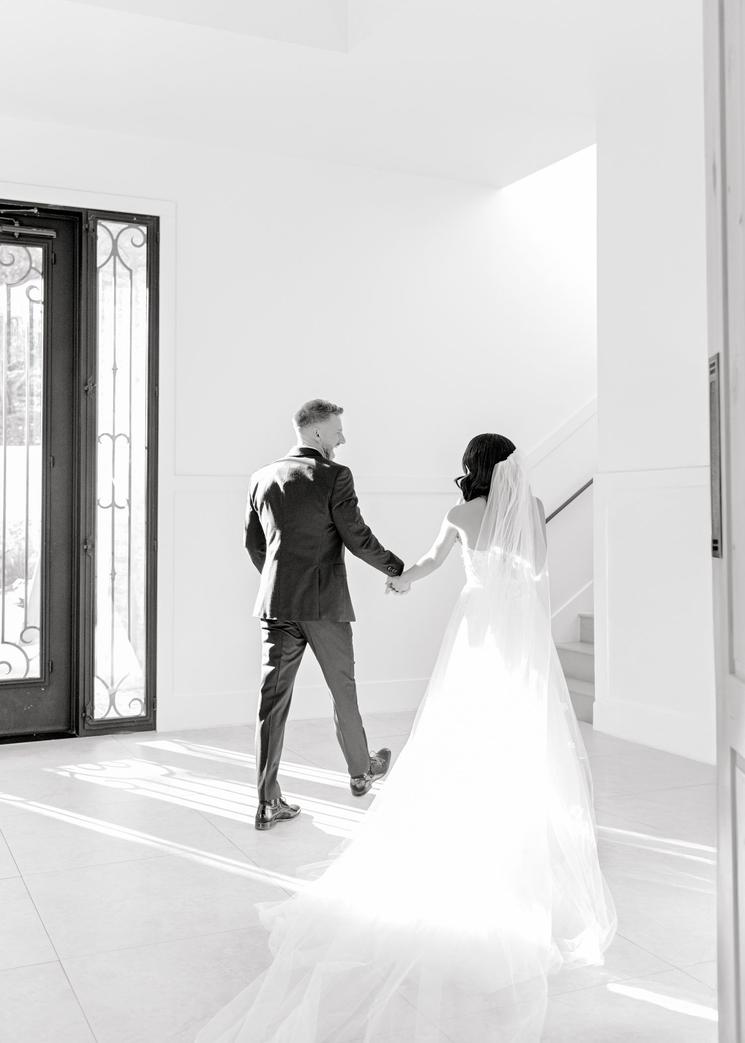 Artistic black and white photo series showing a figure dancing in an empty white room with natural light from windows.
