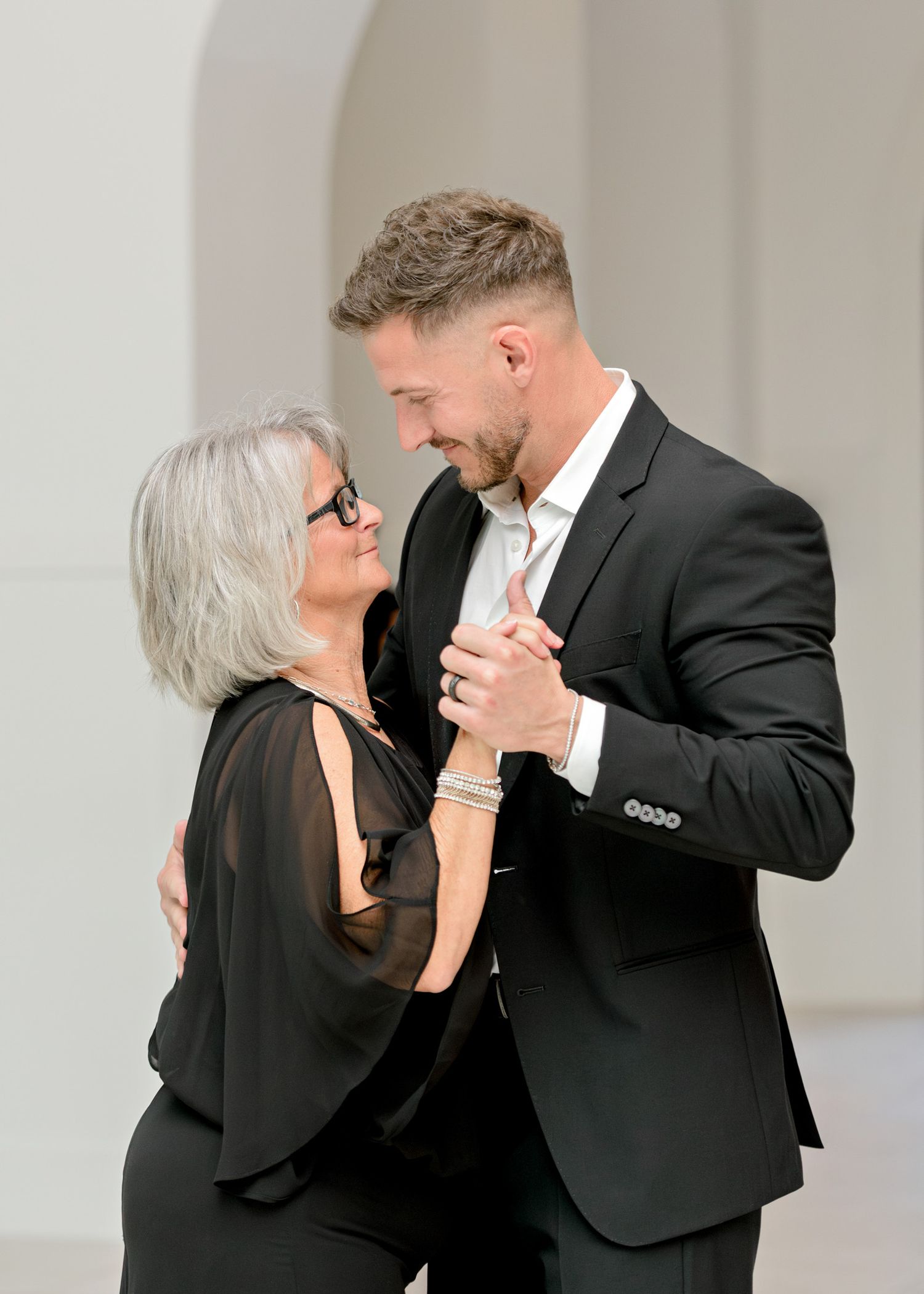 A series of four photos showing a tender dance between two people in formal attire at an elegant venue.