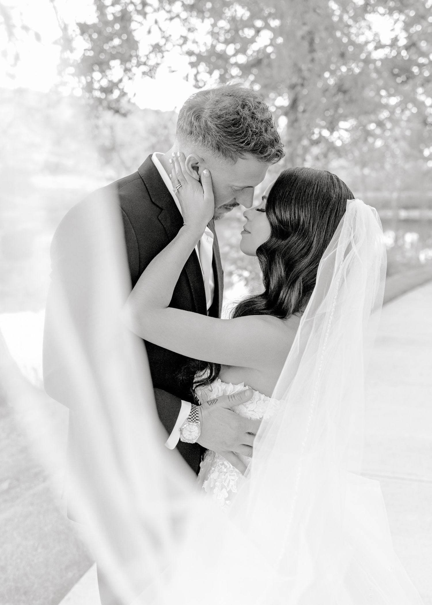 A romantic black and white wedding photo series showing tender moments between a couple in an outdoor setting.