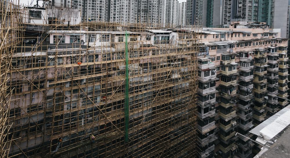 Aerial view of Hong Kong residential buildings covered in bamboo scaffolding during renovation work.