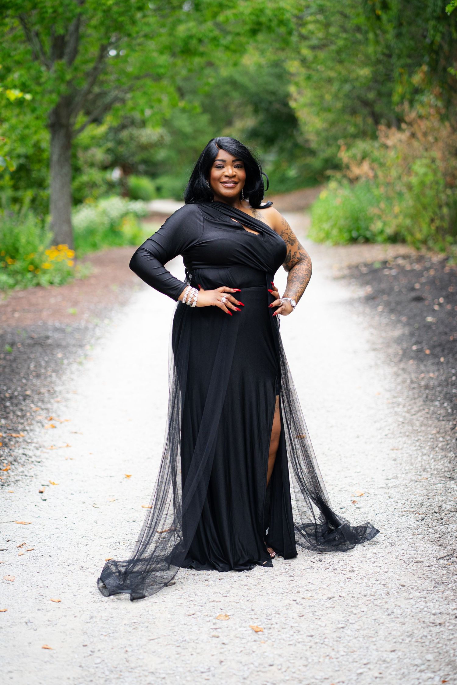 Artistic outdoor portrait series in flowing black dress with tulle on gravel path.