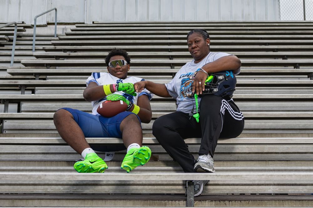 Player rests on metal bleachers after sports practice wearing bright green cleats.