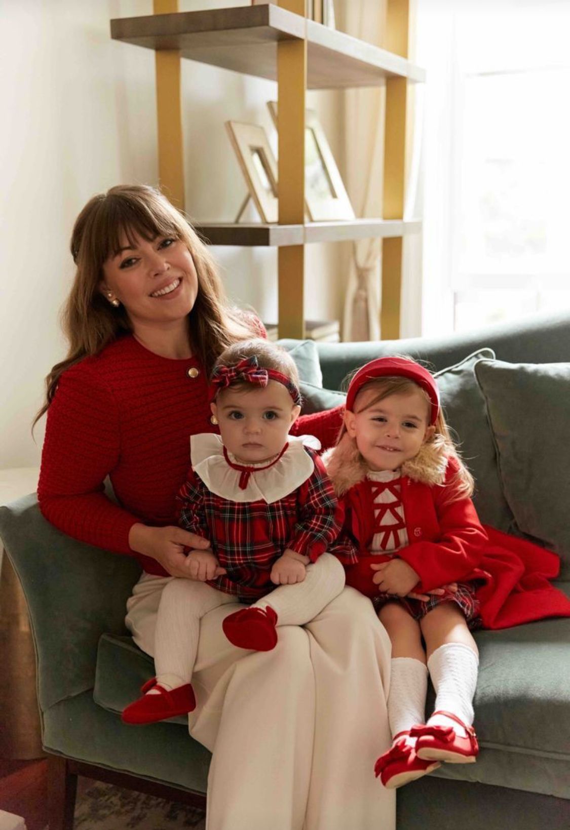 Collection of holiday children's dresses and outfits in navy blue and emerald green plaid with velvet details and bows.