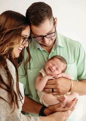 A heartwarming series of photos showing parents cradling and bonding with their newborn baby while wearing green and white.