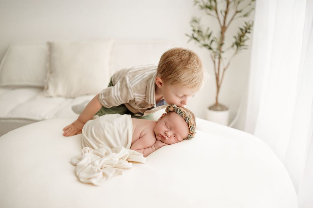 Four soothing black and white images showing a sleeping baby in cozy white bedding.