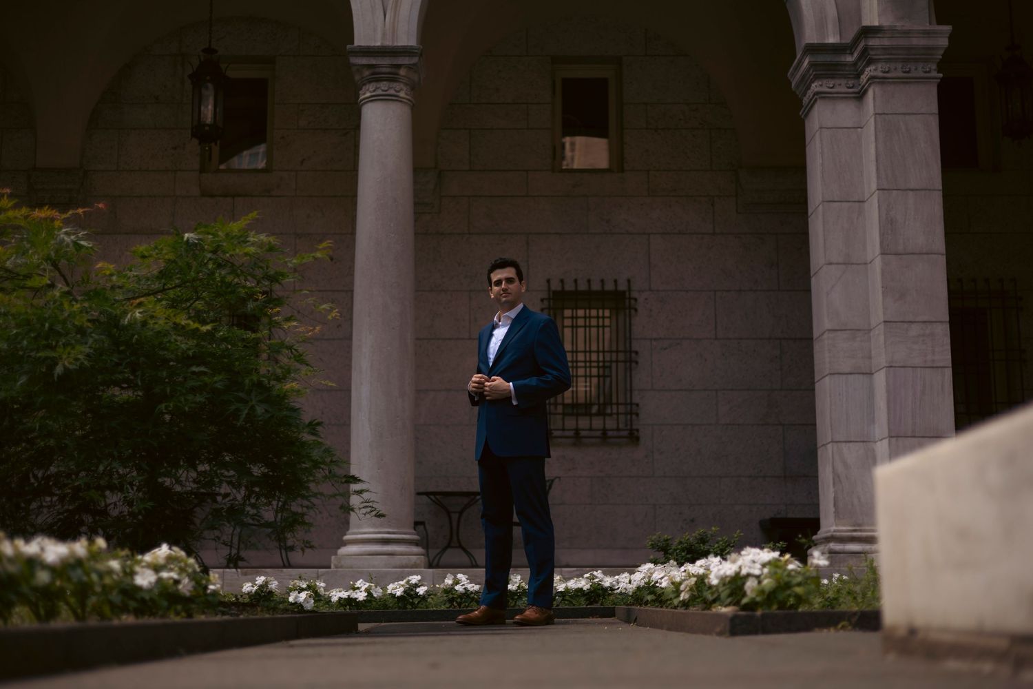 A grand colonnade stretches along the exterior of a historic stone building with ornate architectural details.