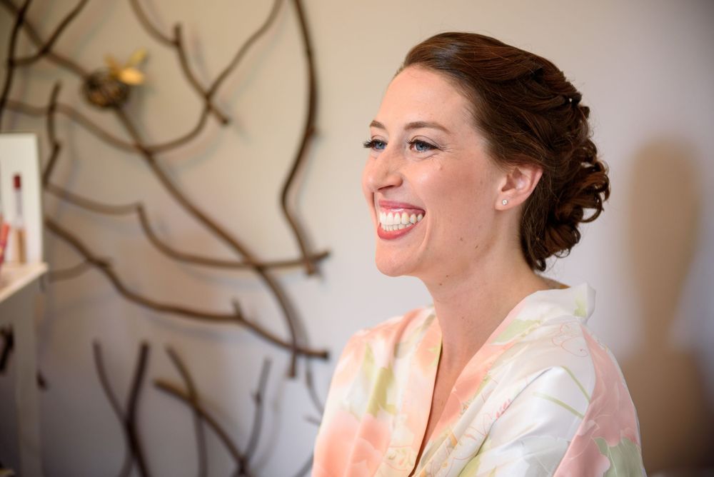 Joyful expressions and laughter during wedding preparations in natural window light.