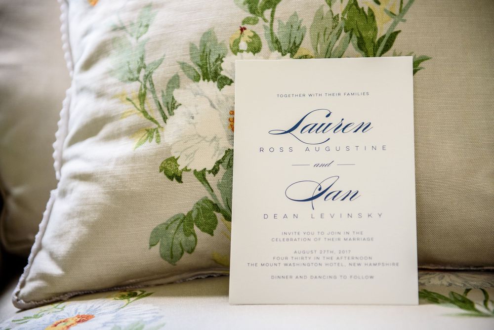 Wedding invitation suite with calligraphy name cards and floral pillow details.