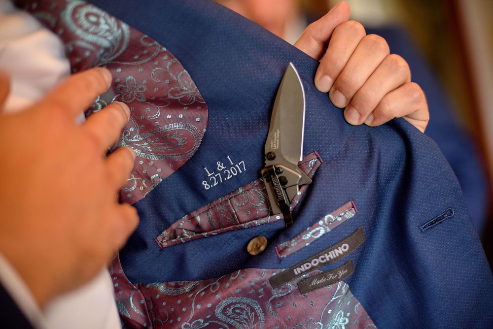 Close-up details of blue suit jackets and ties during wedding preparation.