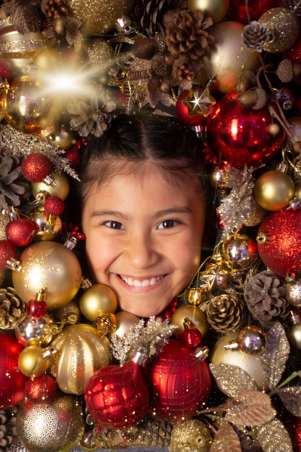 Festive holiday decorations with red and gold ornaments, pinecones, and glittering lights create a magical Christmas frame.