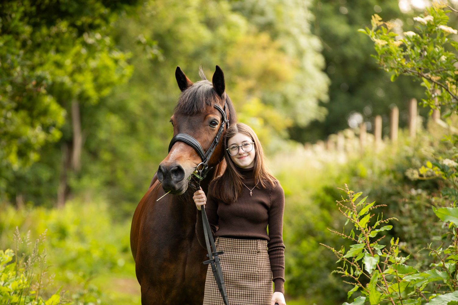 A beautiful black and white paint horse stands with a person on a sunny autumn day outdoors.