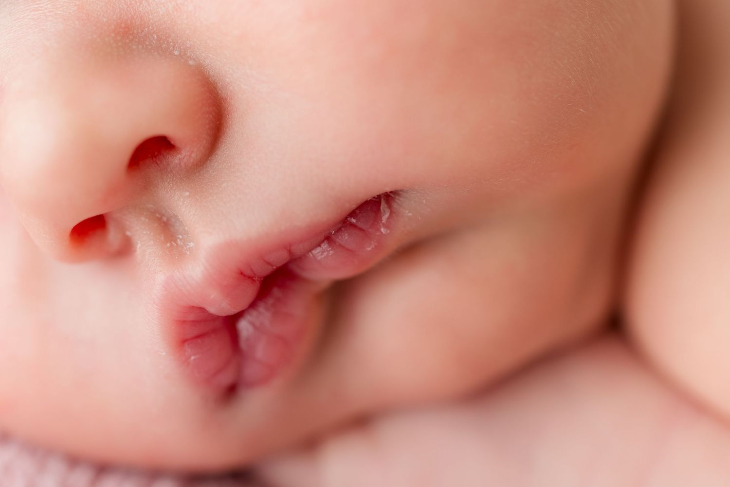 Extreme macro close-up showing delicate features of peacefully sleeping newborn baby.