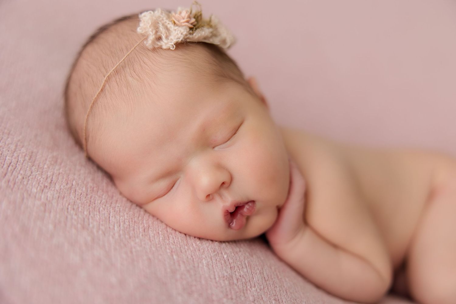 Series of peaceful newborn baby portraits on pink backdrop showing various sleeping poses.