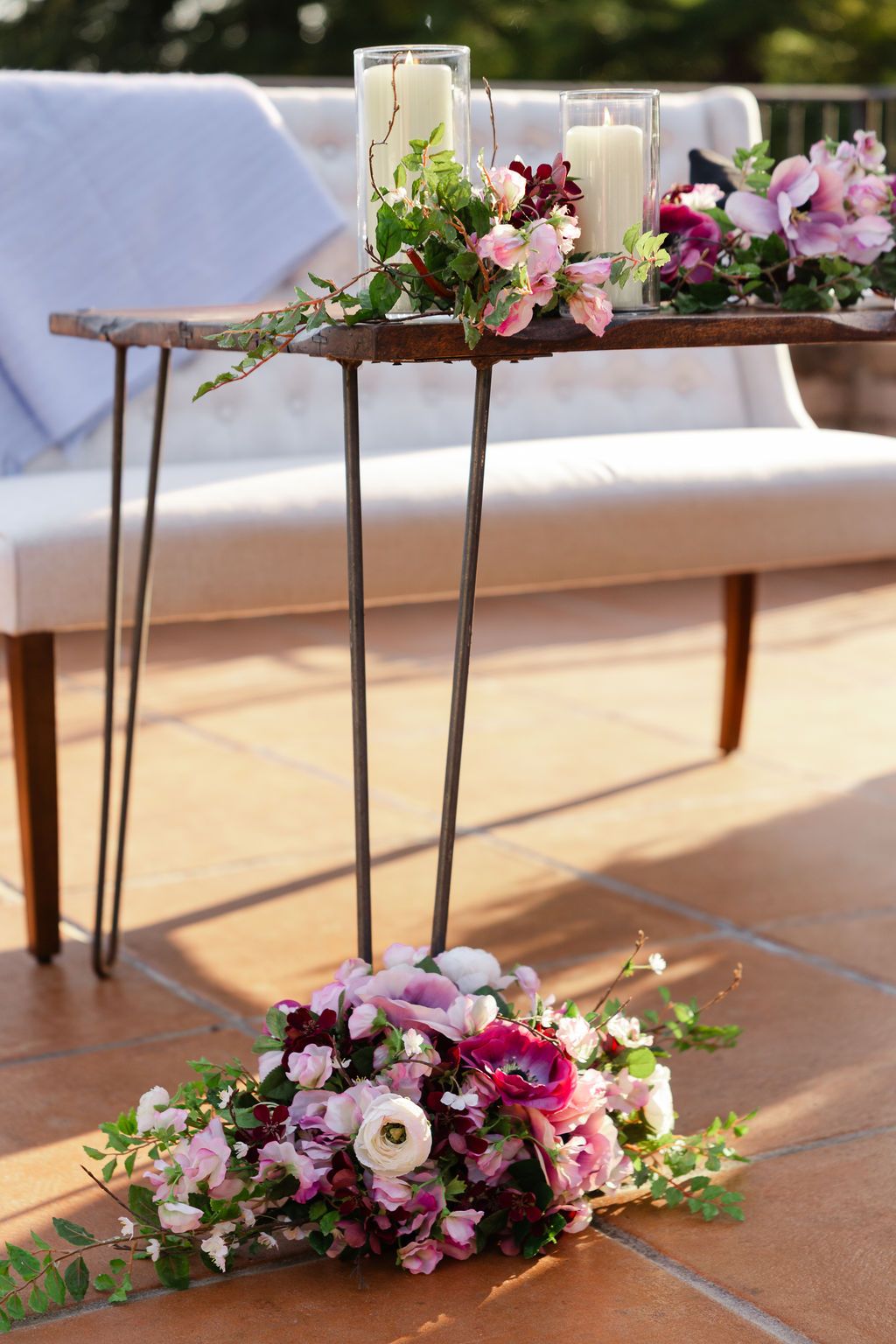 A close-up view of fresh floral arrangements with pink and white blooms displayed on a wooden surface in natural lighting.