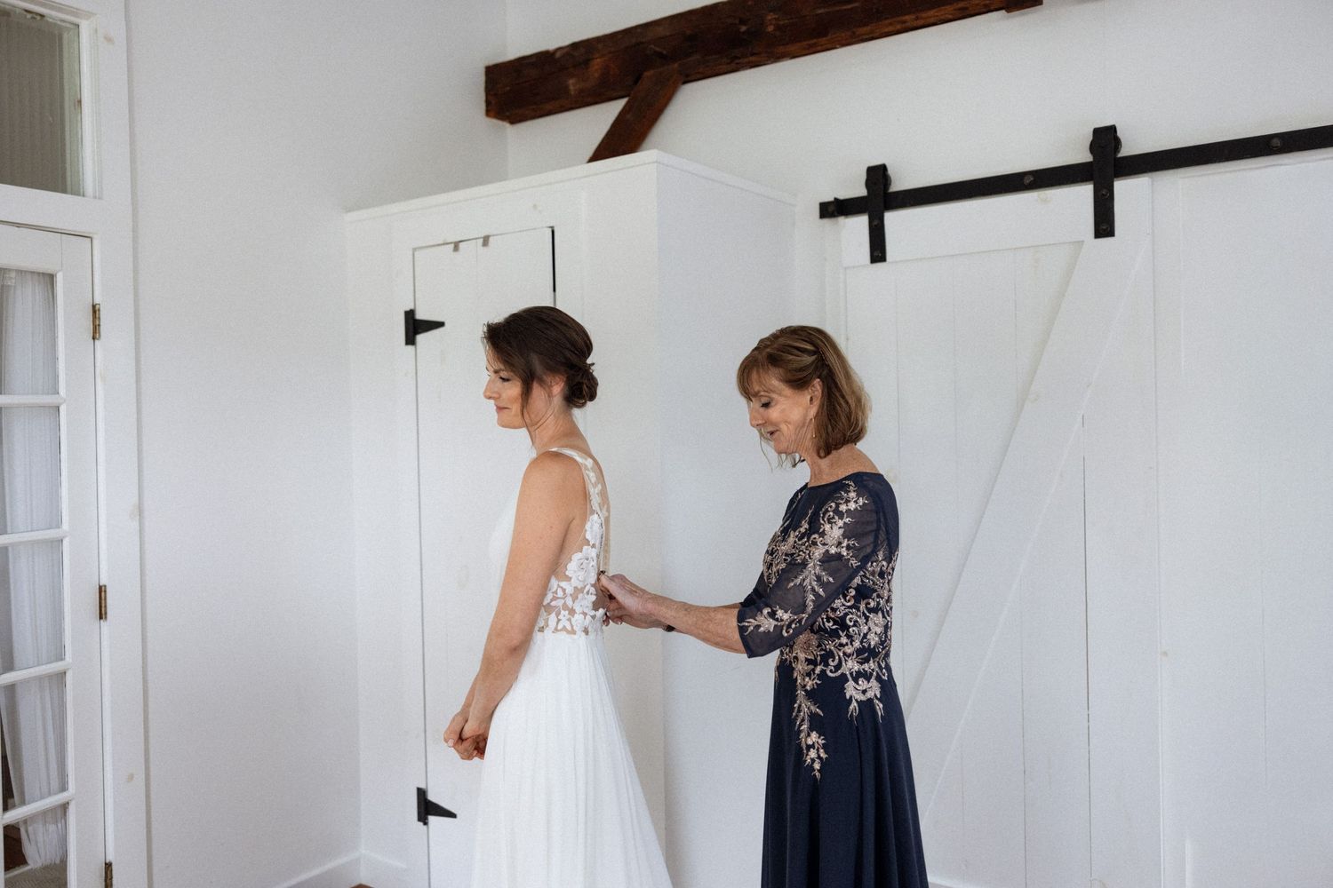 Getting ready sequence showing wedding dress preparations in a rustic white room.