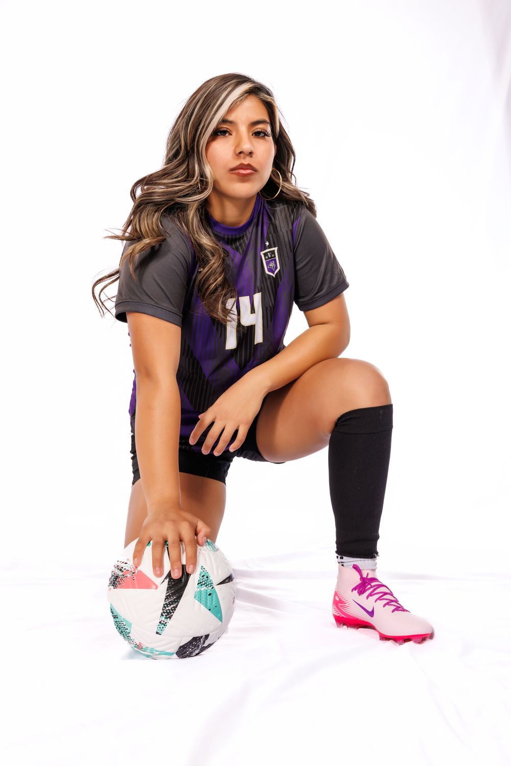 Athletic figure in purple and black jersey sits on white background with colorful sneakers in dynamic poses.